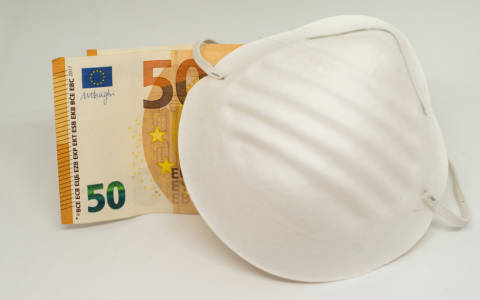 Euro-Schein hinter Schutzmaske