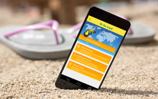 Smartphone mit Reise-App am Strand