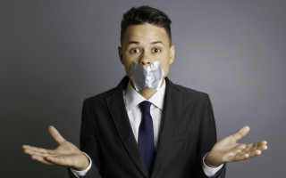 Businessman with silver tape over his mouth