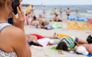 Frau telefoniert am Strand
