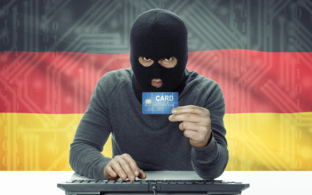 Hacker mit Kreditkarte vor Deutschlandflagge