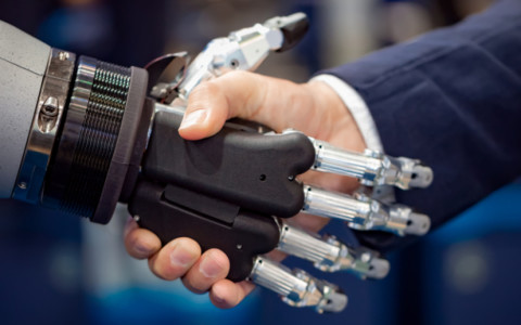 Mensch schüttelt Roboter die Hand
