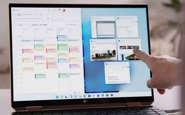Hand zeigt auf einen Notebook-Bildschirm mit Windows 11