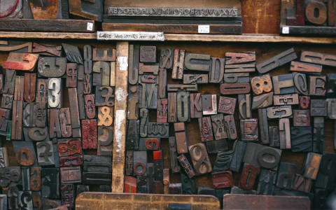 Alte, etwas abgenutzte Holzbuchstaben sind in verschiedenn Grössen ausgelegt