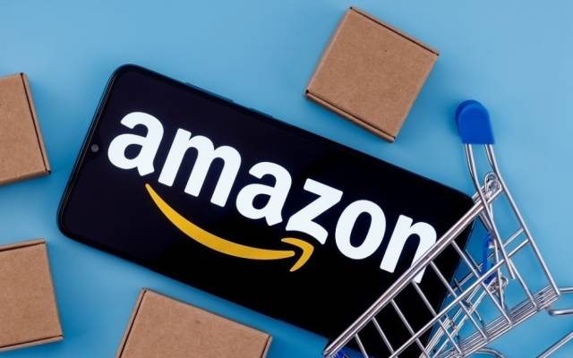 Amazon-Schriftzug auf einem Smartphone mit Paketen