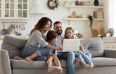 Familie sitzt auf dem Sofa und surft im Internet