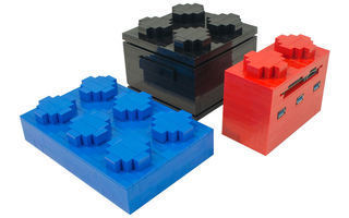 Modularer Lego-Computer: Ein blaues Lego-Steinchen für die Festplatte, ein schwarzes oder gelbes für das NUC-Motherboard und ein roter Baustein für USB-Hub und Kartenleser.