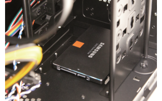 SSD anschließen: Die SSD wird auf dem Gehäuseboden verschraubt, mit der Anschlussseite Richtung Mainboard. Verwenden Sie kleine Schrauben, um die SSD von außerhalb des Gehäuses zu fixieren. Verbinden Sie die SSD einerseits mit dem Netzteil, andererseits m